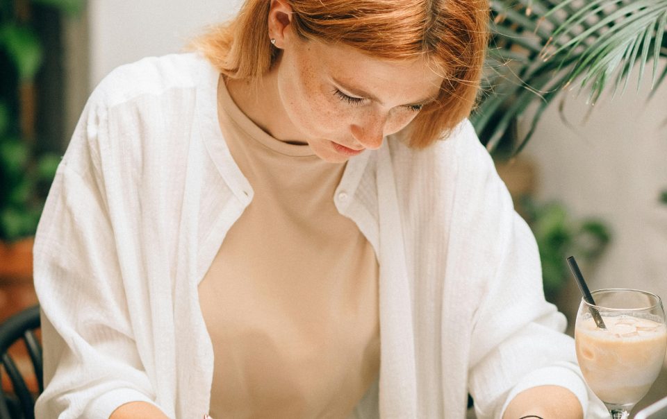 A Woman Sitting on a Table While Looking at a Spreadsheet